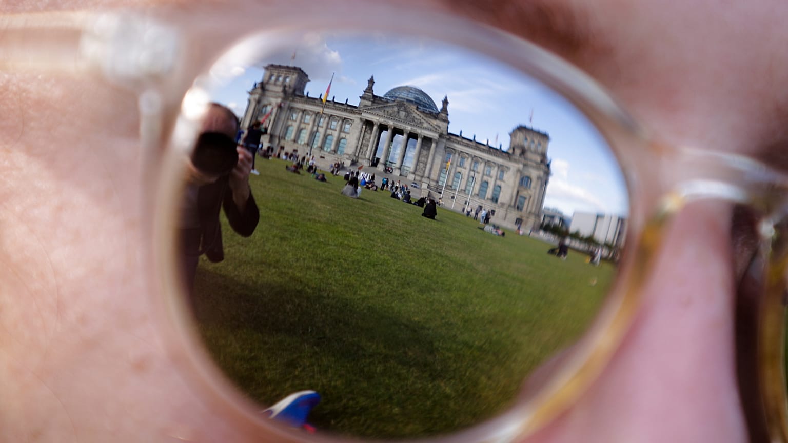 Das Archivfoto vom 22. September 2017 zeigt das Reichstagsgebäude, in dem der Deutsche Bundestag seinen Sitz hat, gespiegelt in der Sonnenbrille einer Frau in Berlin.
