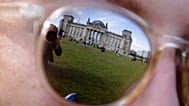 Das Archivfoto vom 22. September 2017 zeigt das Reichstagsgebäude, in dem der Deutsche Bundestag seinen Sitz hat, gespiegelt in der Sonnenbrille einer Frau in Berlin.