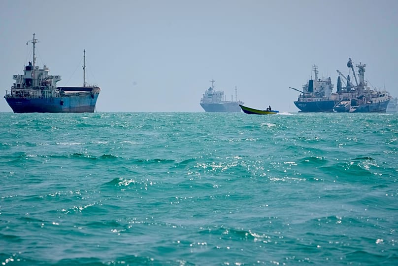 A motorboat passes commercial vessels anchored in the Strait of Hormuz off Bandar Abbas, Iran, on 6 September 2026. 