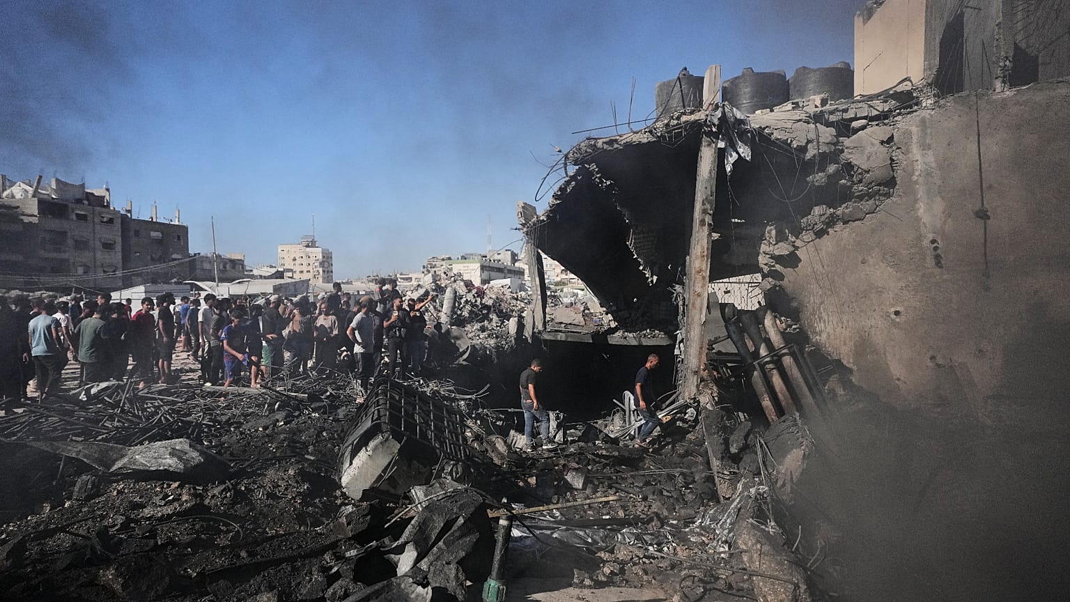 فلسطينيون يجمعون ويتفقدون أنقاض مبنى دمر في غارة جوية إسرائيلية على مدينة غزة، الاثنين 24 أغسطس 2026. (AP Photo/جهاد الشرافي)