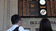A couple stands in front of a billboard displaying canceled trains during a nationwide general strike called by the labor unions, in Milan, Italy, Friday, May 29, 2026. (AP Ph