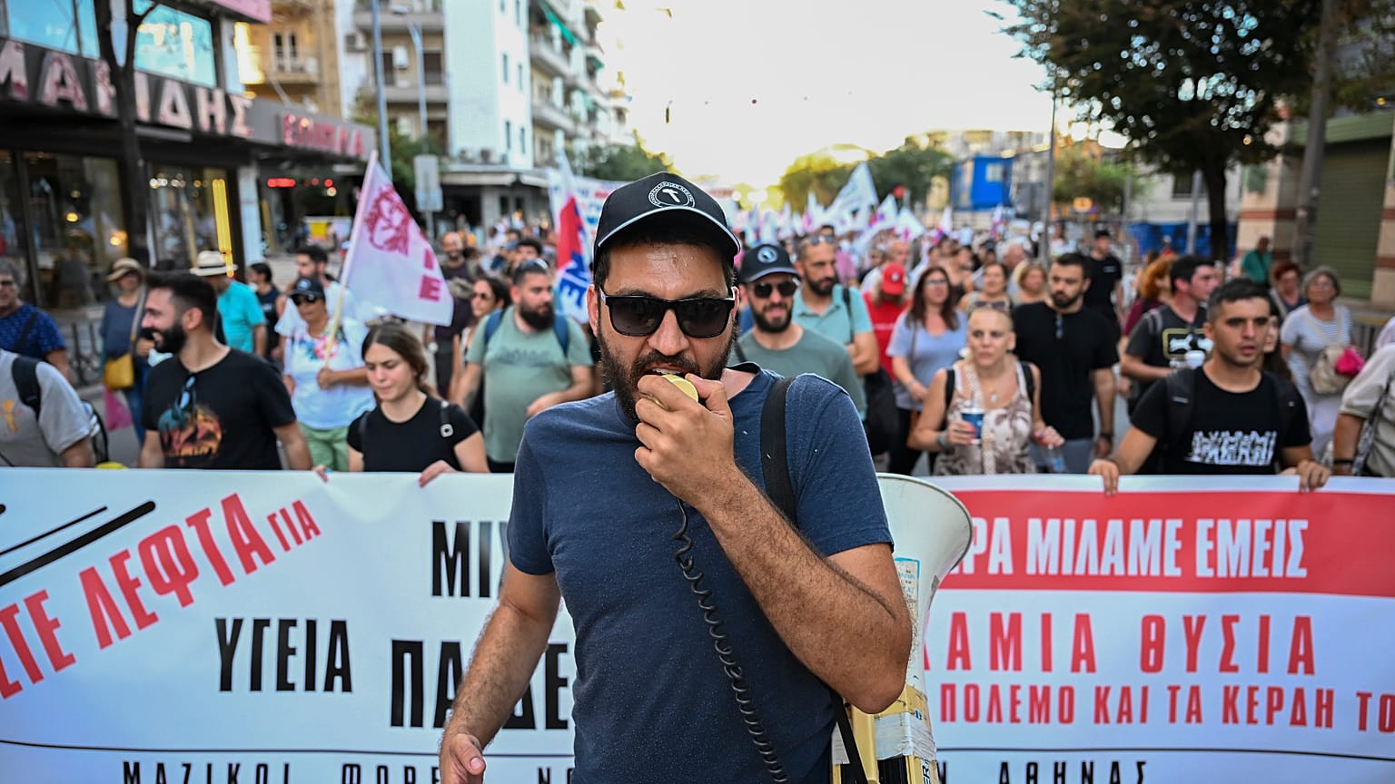 Ένας διαδηλωτής φωνάζει συνθήματα με μεγάφωνο κατά τη διάρκεια συγκέντρωσης διαμαρτυρίας κοντά στη διεθνή εμπορική έκθεση της Θεσσαλονίκης, στη βόρεια πόλη της Θεσσαλονίκης, σ