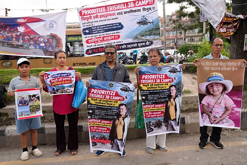 Relatives of recent flash flood victims hold banners urging authorities to step up efforts to find their missing loved ones during a demonstration in Kathmandu, 7 September, 2