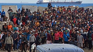 Migrantes que cruzaron de Marruecos a España regresan a una playa tras haber sido expulsados ​​de la zona en Ceuta, el 21 de agosto de 2026. (Foto AP/Antonio Sempere)
