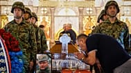 A man kisses the cross as Serbian army servicemen stand around the coffin of the former Bosnian Serb war criminal Ratko Mladić in Belgrade, 7 September 2026