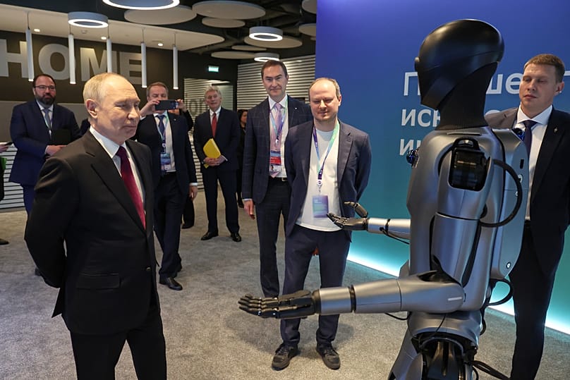 Владимир Путин и человекоподобный робот со встроенным гигачатом Сбербанка на AI Journey 2025 - международной конференции по ИИ и машинному обучению, Москве, 19 ноября 2026 г.