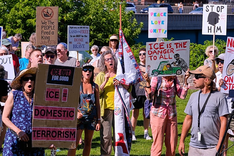 People hold signs during an anti-ICE protest in Biddeford, 17 July, 2026