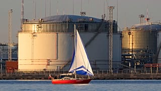 Яхта проплывает мимо нефтехранилища в Санкт-Петербурге, 15 мая 2024
