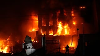 A rescue worker puts out a fire of a building destroyed after a Russian missile attack in Kyiv, 8 September, 2026