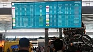Travelers walk past an information board showing disrupted flights at Soekarno-Hatta International Airport in Tangerang, 6 September, 2026