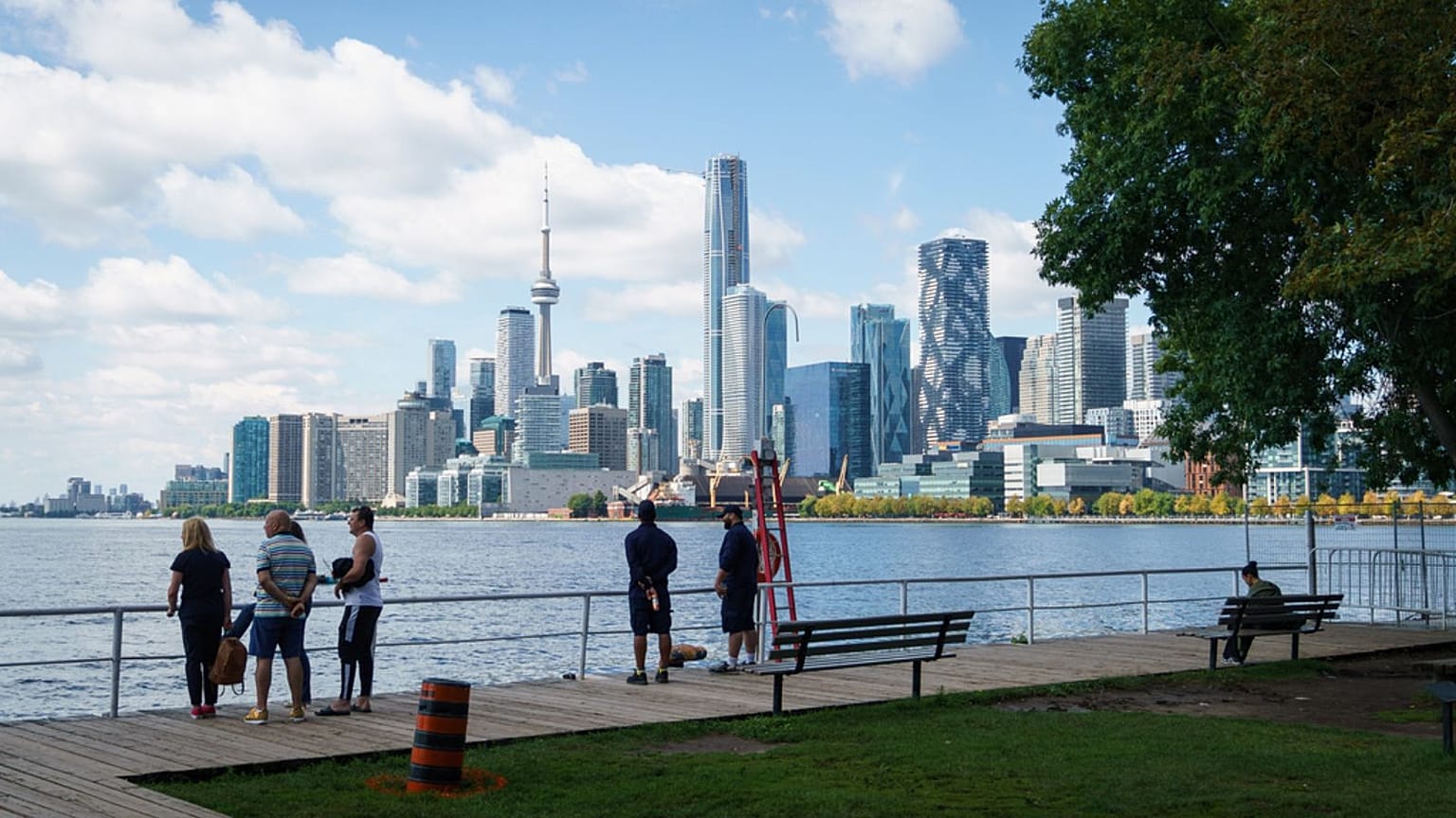 People look out across Lake Ontario from the harbor in Toronto