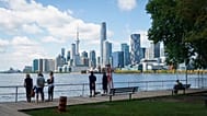 People look out across Lake Ontario from the harbor in Toronto