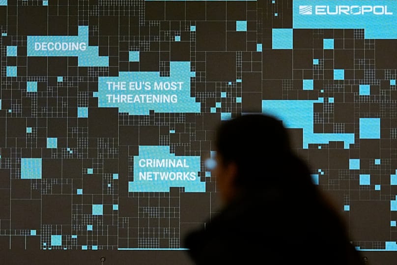 A woman walks by a projection at the Residence Palace in Brussels, 5 April, 2024