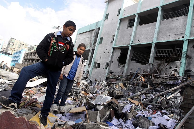 Palestinian students survey the damage at a school in Gaza, dated 2015.