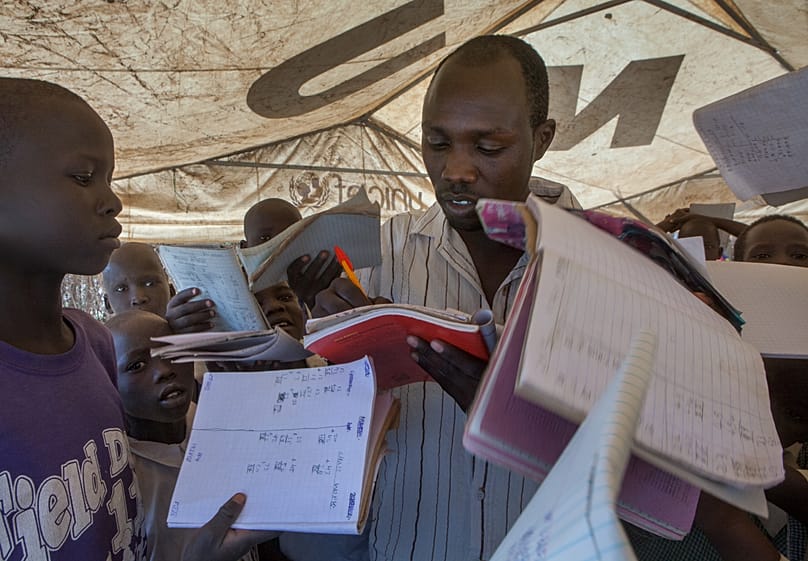 Children crowd an overworked teacher at Unity primary school in the Kakuma refugee camp in North Western Kenya.