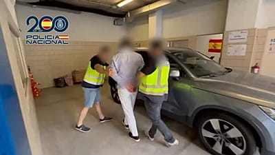 Uno de los detenidos, siendo escoltado por la Policía Nacional