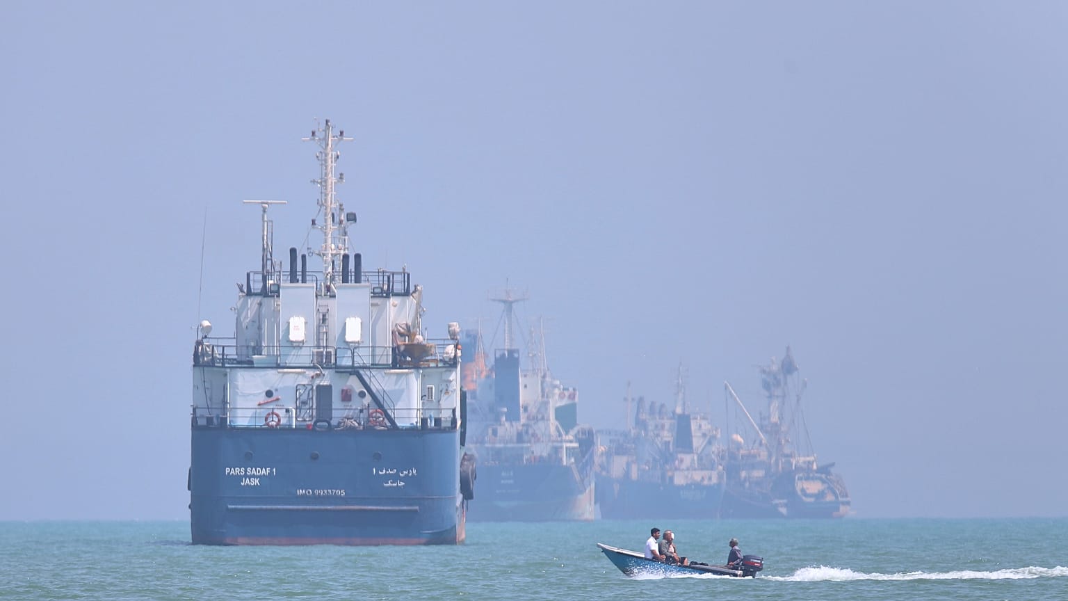 FILE: A small motorboat passes anchored vessels in the Strait of Hormuz off Bandar Abbas, Iran, 11 June 2026
