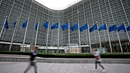 FILE - European Union flags flap in the wind as pedestrians walk by EU headquarters in Brussels, Wednesday, Sept. 20, 2023. (AP Photo/Virginia Mayo, File)