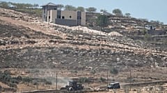 Veículos do exército israelita operam junto a casas palestinianas cercadas por colonos israelitas na aldeia ocupada de Qusra, a sul de Nablus, quinta-feira, 13 de agosto 2026
