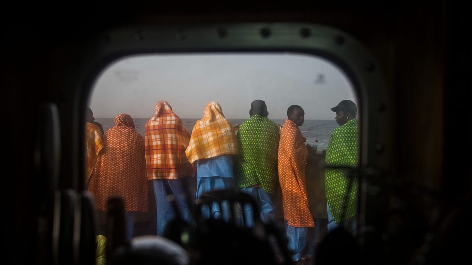 ينظر اللاجئون والمهاجرون الأفارقة، معظمهم من السودان والسنغال، إلى البحر على متن سفينة الإنقاذ الإسبانية غير الحكومية
