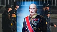 Police officers reflected in a window with a display showing Norway's late King Harald V prior to his funeral in Oslo, 9 September, 2026