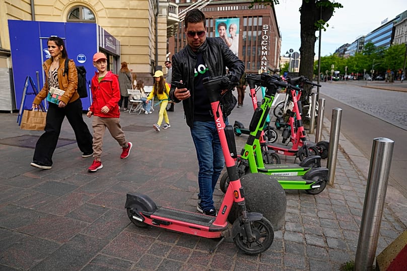 A man parks an electric scooter in a street in Helsinki, 29 May, 2023