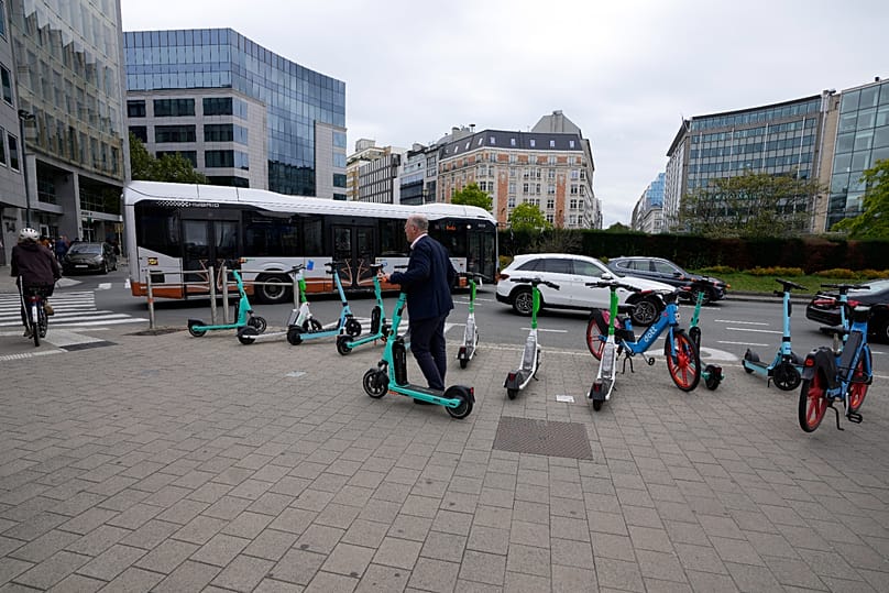 A man hires an electric scooter on Shuman Circle in the European Quarter of Brussels, 20 September, 2023