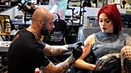 Tattoo artist Thiago Miranda tattooing a woman's arm