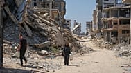 يحمل الفلسطينيون عبوات مياه أثناء سيرهم وسط أنقاض المباني التي دمرتها الغارات الجوية الإسرائيلية خلال الحرب مع حماس، في مدينة غزة، يوم الاثنين 24 أغسطس 2026.
