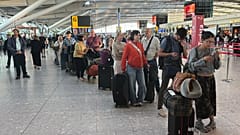 Passengers wait in line at Heathrow Airport in London, during an air traffic control problem that disrupted travel across Britain.