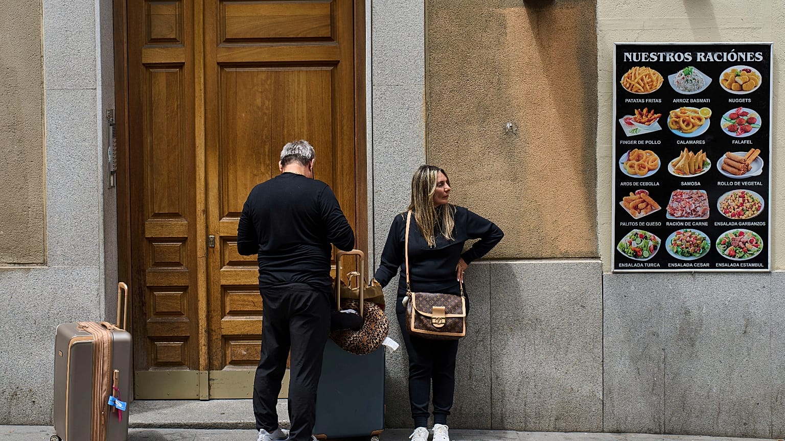 Tourists wait at the entrance of a building in downtown Madrid, Spain, Tuesday, 3 June, 2025. 
