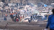 Migrants stand near their tents at El Trampolín beach in the Spanish exclave of Ceuta