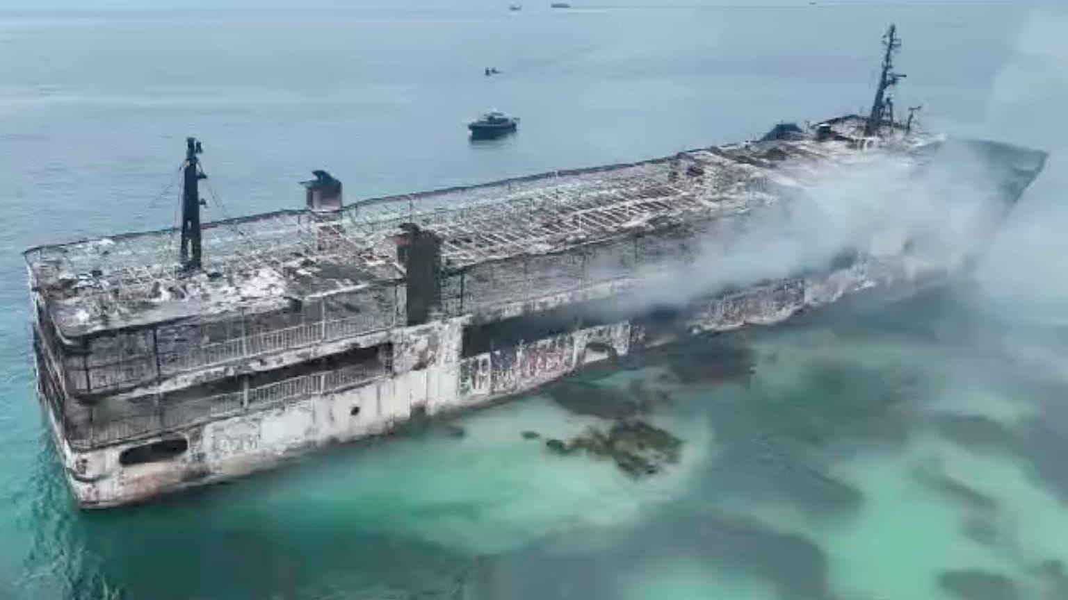 This image taken from video provided by the Philippine Coast Guard, shows smoldering remains of ferry that caught fire off wester Philippines on 10 September 2026.