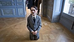 Visitors looks at "him", a controversial sculpture of Adolf Hitler, an art installation by Maurizio Cattelan.