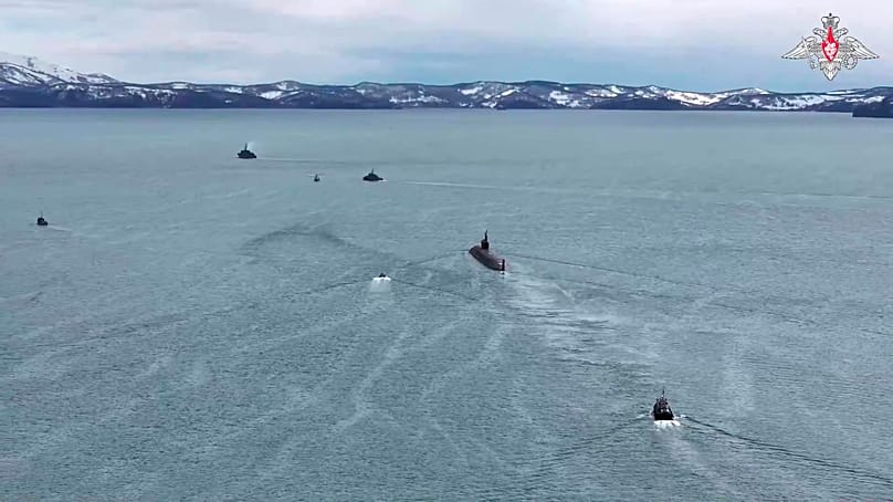 In this image from a video provided by Russian Defense Ministry Press Service on Thursday, 21 May 2026, a Russian nuclear submarine is escorted by boats during drills.