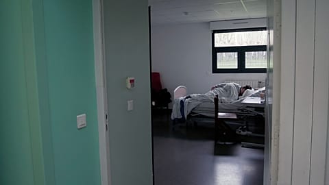 A patient sleeps in his room in the emergency department of Rouvray psychiatric hospital in Rouen, western France, Wednesday 25 November 2020.