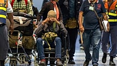 Hombres sudafricanos que, según se afirma, fueron engañados para combatir del lado de Rusia en la guerra de Ucrania llegan a un aeropuerto internacional de Sudáfrica