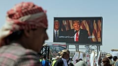 هواداران حوثی‌ها در جریان یک راهپیمایی هفتگی ضدآمریکایی و ضداسرائیلی در صنعا، پایتخت یمن، در زیر بنری از دونالد ترامپ، رئیس‌جمهور آمریکا، ۱۶ مه ۲۰۲۵