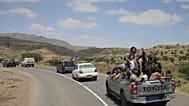 يحتفل اليمنيون أثناء ركوبهم شاحنة صغيرة في منطقة بني مطر باليمن، وهم يتبعون قافلة تقل سجناء حوثيين تم إطلاق سراحهم بعد استيلاء الحوثيين على المدينة الساحلية بجنوب البحر الأحمر