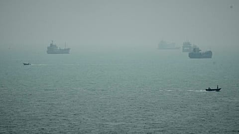 Motorboats travel past commercial vessels anchored amid haze in the Strait of Hormuz off Bandar Abbas, Iran, Monday, Sept. 7, 2026.