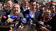 Far-right leader Marine Le Pen and Far-right party National Rally president Jordan Bardella as they arrive to visit a market in La Fleche, western France, 8 July.