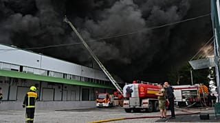 Firefighters put out a fire at warehouse stores after a Russian air attack in Odesa, Ukraine, Sunday, Sept. 13, 2026. 