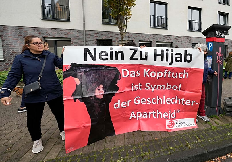 Frauen halten vor der Zentralmoschee in Köln am 14. Oktober 2022, ein Banner mit der Aufschrift: "Nein zum Hijab – das Kopftuch ist ein Symbol für Geschlechterapartheid."