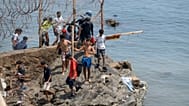 Varias personas traspasan las alambradas mientras intentan cruzar desde la ciudad marroquí de Fnideq, en el norte del país, hasta el enclave español de Ceuta, 31 de julio 2026