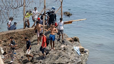 Varias personas traspasan las alambradas mientras intentan cruzar desde la ciudad marroquí de Fnideq, en el norte del país, hasta el enclave español de Ceuta, 31 de julio 2026