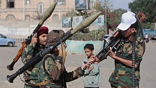 متمردون حوثيون في اليمن يتبادلون الحديث أثناء فحص أسلحتهم خلال حملة تعبئة في صنعاء، اليمن