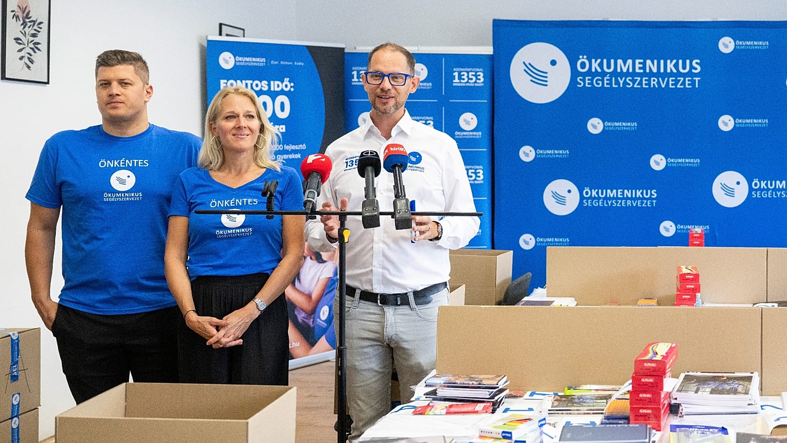 Gáncs Kristóf, az Ökumenikus Segélyszervezet elnöke (j) beszédet mond tanszercsomagok összeállításán a szervezet Iskolakezdés együtt! segélyakcióján