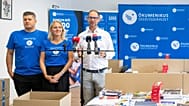 Gáncs Kristóf, az Ökumenikus Segélyszervezet elnöke (j) beszédet mond tanszercsomagok összeállításán a szervezet Iskolakezdés együtt! segélyakcióján