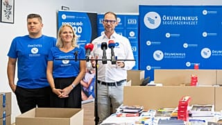 Gáncs Kristóf, az Ökumenikus Segélyszervezet elnöke (j) beszédet mond tanszercsomagok összeállításán a szervezet Iskolakezdés együtt! segélyakcióján