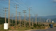 A truck passes near electricity posts as a power plant is seen in the background, outside the northern city of Kozani on Thursday, June 2, 2022.